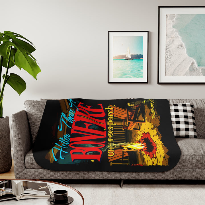 Hotter than a bonfire on your ex's porch slogan by Thorn Ridge® on a black sherpa blanket with the image of a bonfire on a porch.
