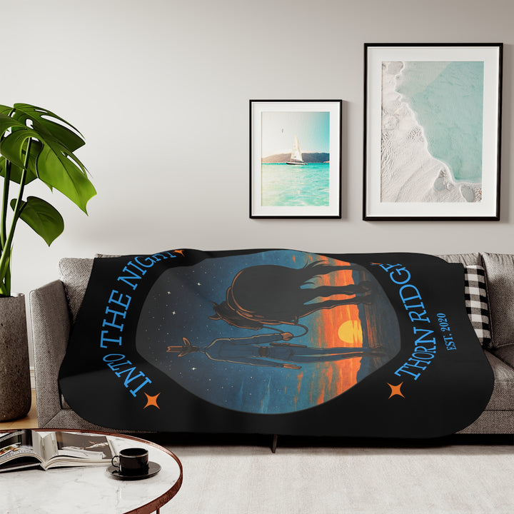 Into the Night by Thorn Ridge® EST 2020 black sherpa blanket with a circle image of a cowboy leading his horse into the sunset with the night sky with stars above them.