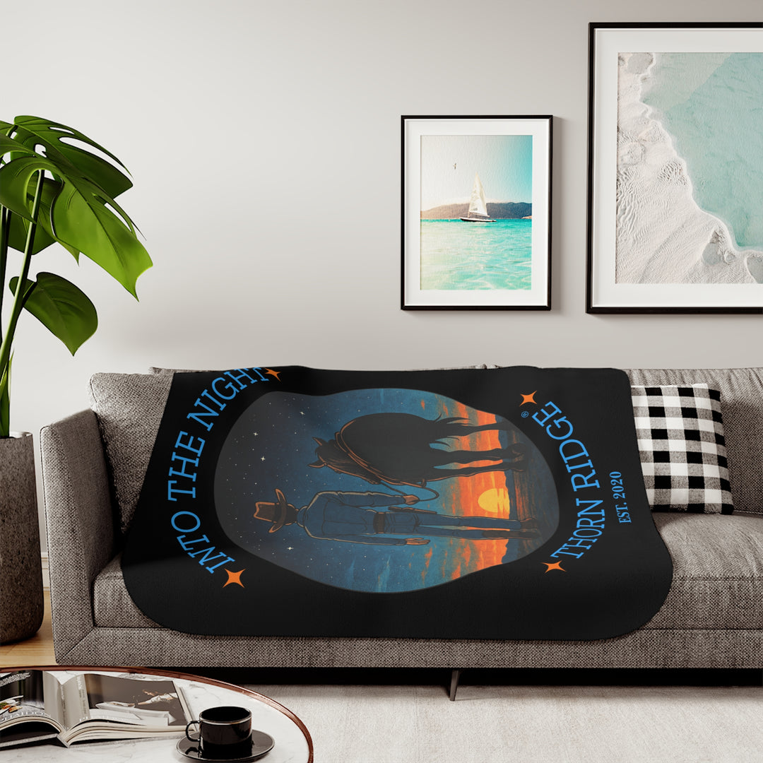 Into the Night by Thorn Ridge® EST 2020 black sherpa blanket with a circle image of a cowboy leading his horse into the sunset with the night sky with stars above them.