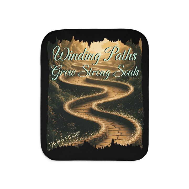 Winding Paths Grow Strong Souls black sherpa blanket with an image of a winding golden brick path through a forest with lights on top of the bricks that edge the path. By Thorn Ridge®