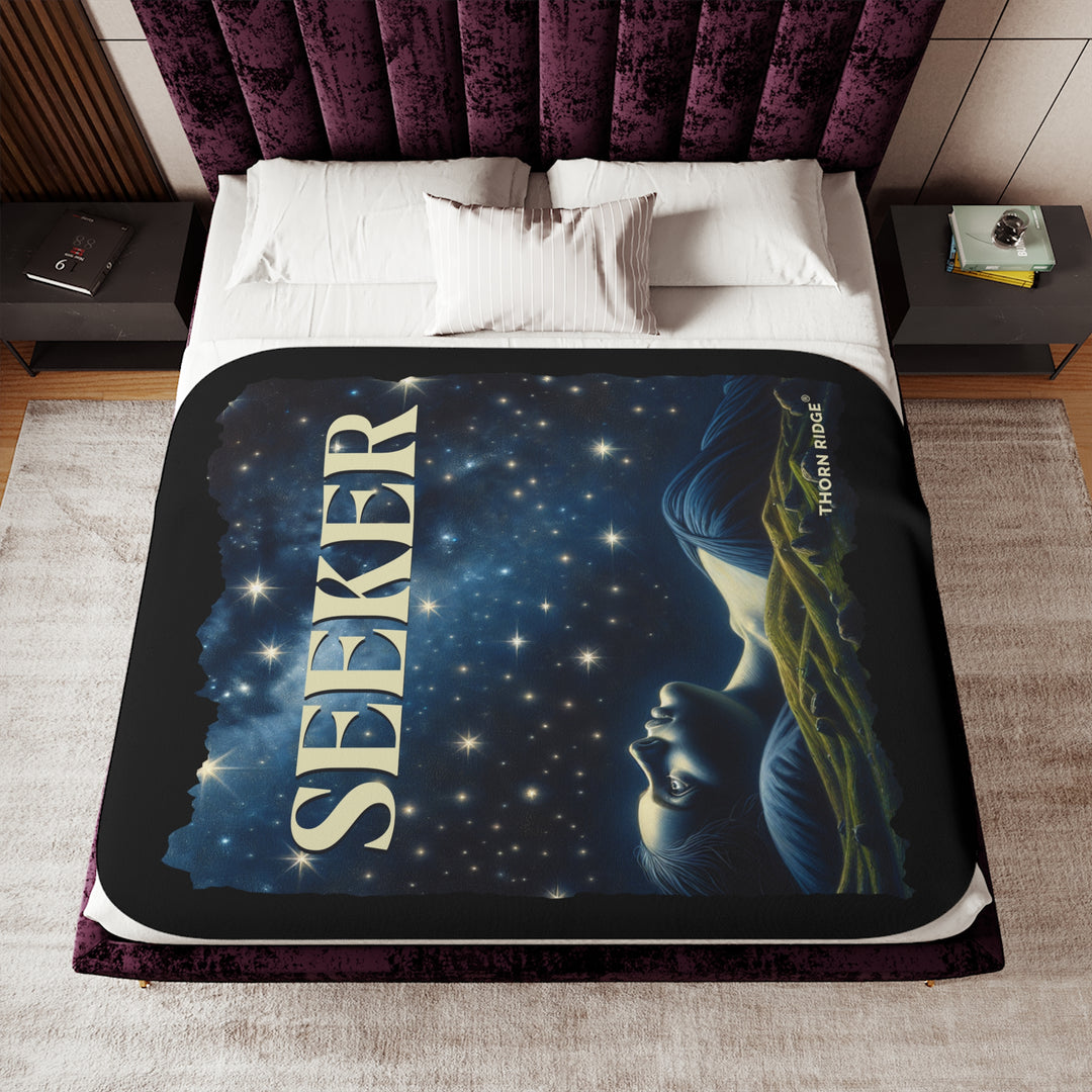 Seeker sherpa blanket in blacks and blues featuring the night sky and a woman laying on the ground stargazing. Branded Thorn Ridge®