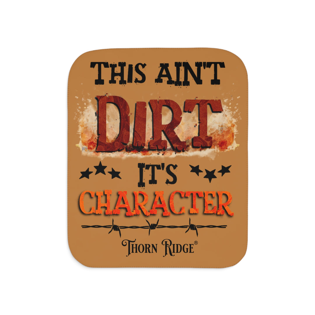 This ain't dirt, it's character slogan by Thorn Ridge® on a light brown sherpa blanket.