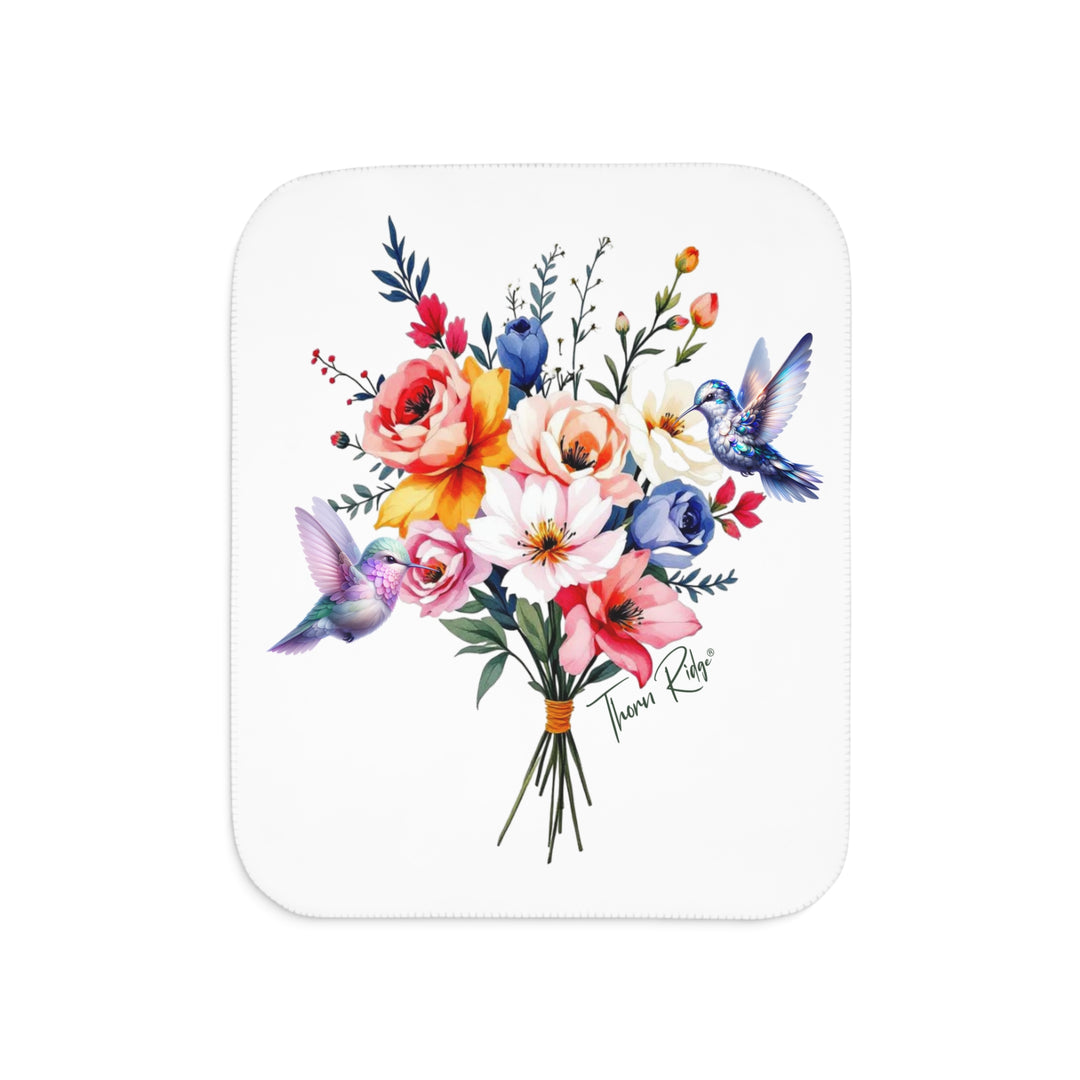 Colorful floral arrangement with hummingbirds on a white sherpa blanket branded Thorn Ridge®