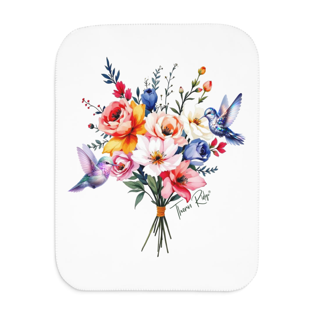 Colorful floral arrangement with hummingbirds on a white sherpa blanket branded Thorn Ridge®