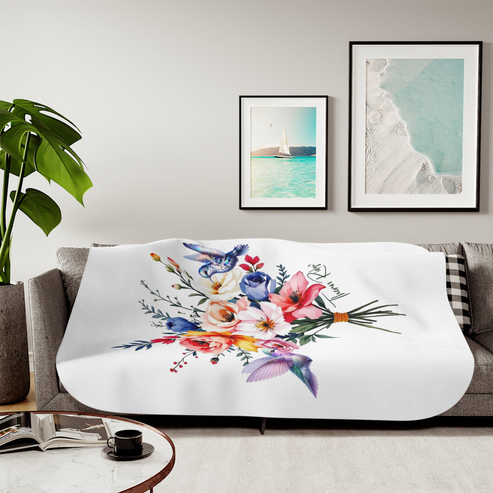 Colorful floral arrangement with hummingbirds on a white sherpa blanket branded Thorn Ridge®