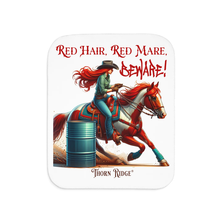 white sherpa blanket with a graphic of a redheaded woman on a tobiano  chestnut horse racing around a barrel and text 'Red Hair, Red Mare, Beware!' by Thorn Ridge®.