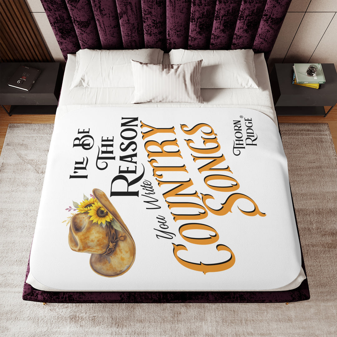 Decorative white sherpa blanket with a yellow sunflower cowgirl hat, sunflower, and text 'I'll be the reason you write country songs' by Thorn Ridge®