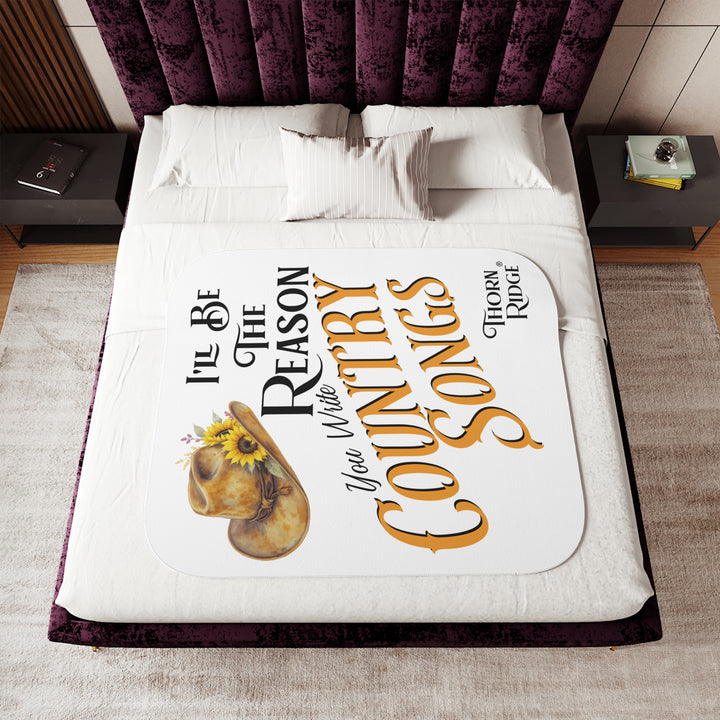 Decorative white sherpa blanket with a yellow sunflower cowgirl hat, sunflower, and text 'I'll be the reason you write country songs' by Thorn Ridge®