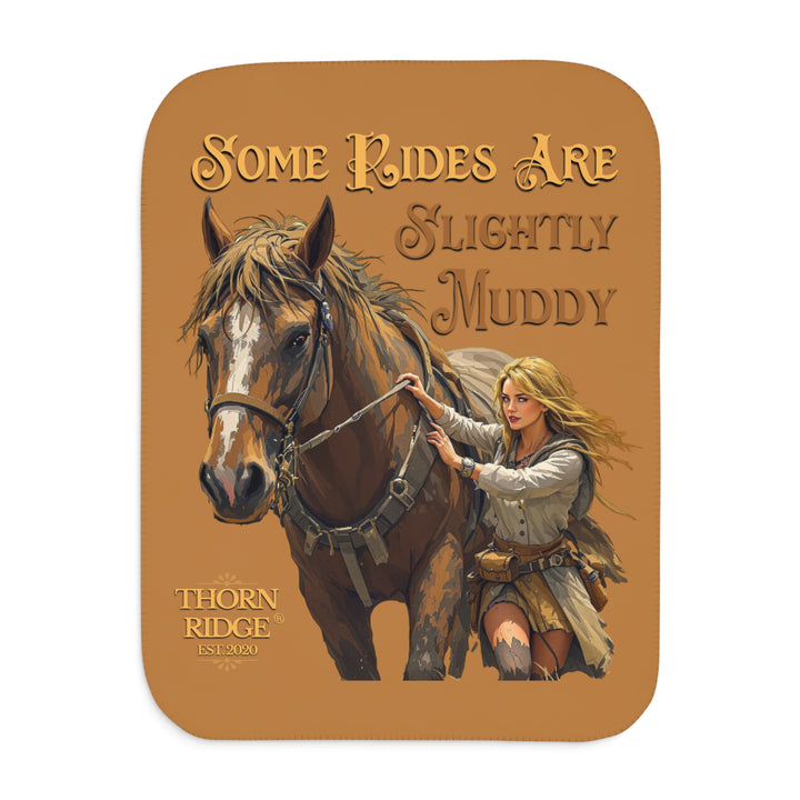 Some Rides Are Slightly Muddy tan sherpa blanket with an illustration of a draft horse in tack and a blond woman walking beside it both covered in mud and branded Thorn Ridge® EST 2020.