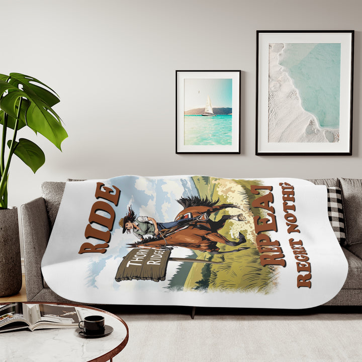 Decorative white sherpa blanket with a horse and rider graphic and text 'Ride Repeat Regret Nothing' and a sign that says the brand name Thorn Ridge®.