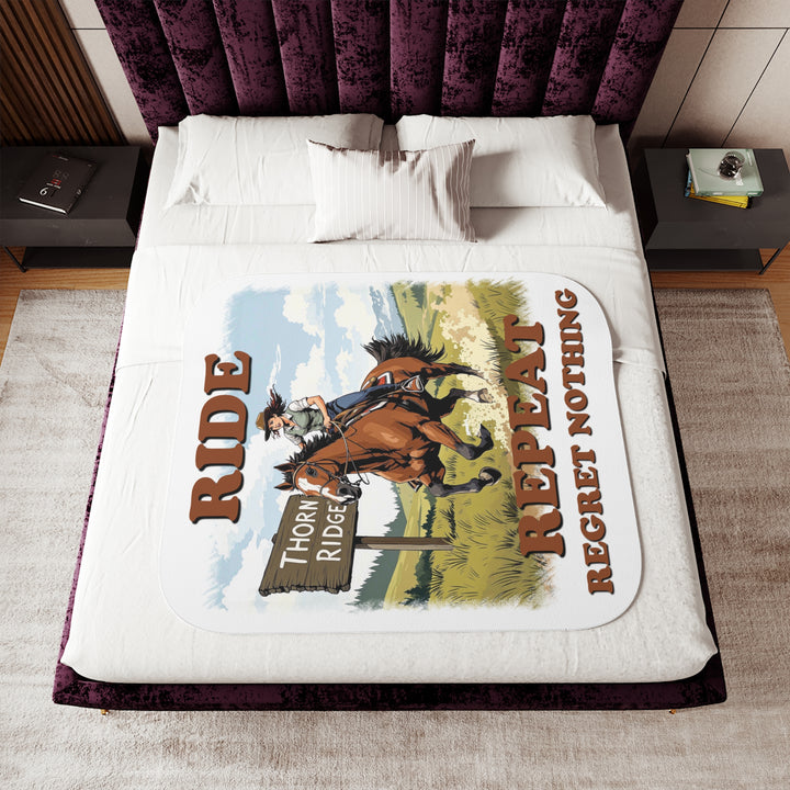 Decorative white sherpa blanket with a horse and rider graphic and text 'Ride Repeat Regret Nothing' and a sign that says the brand name Thorn Ridge®.