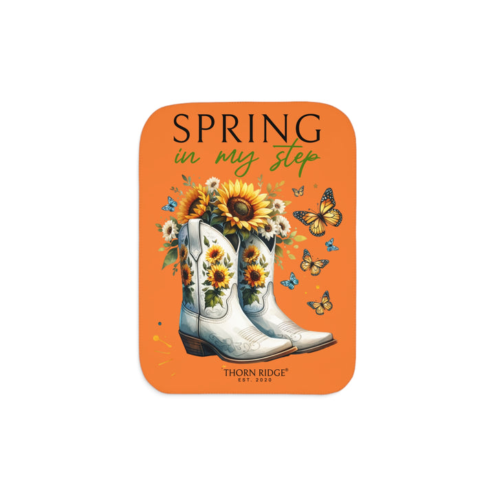 Spring in My Step Orange sherpa blanket with white cowgirl boots filled with sunflowers and sunflower decorations on the boots and butterflys around the boots by Thorn Ridge® Est 2020.