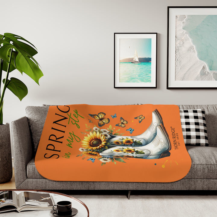 Spring in My Step Orange sherpa blanket with white cowgirl boots filled with sunflowers and sunflower decorations on the boots and butterflys around the boots by Thorn Ridge® Est 2020.