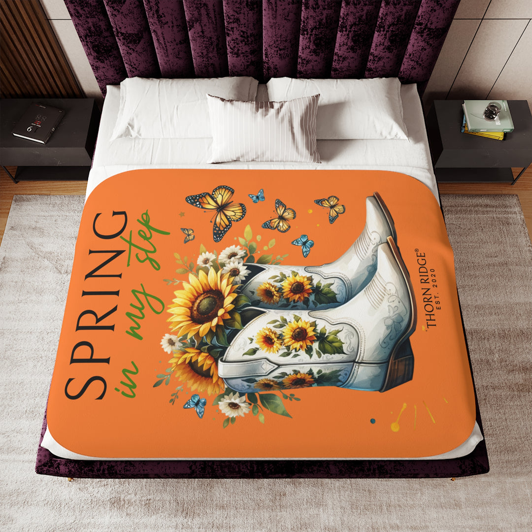 Spring in My Step Orange sherpa blanket with white cowgirl boots filled with sunflowers and sunflower decorations on the boots and butterflys around the boots by Thorn Ridge® Est 2020.