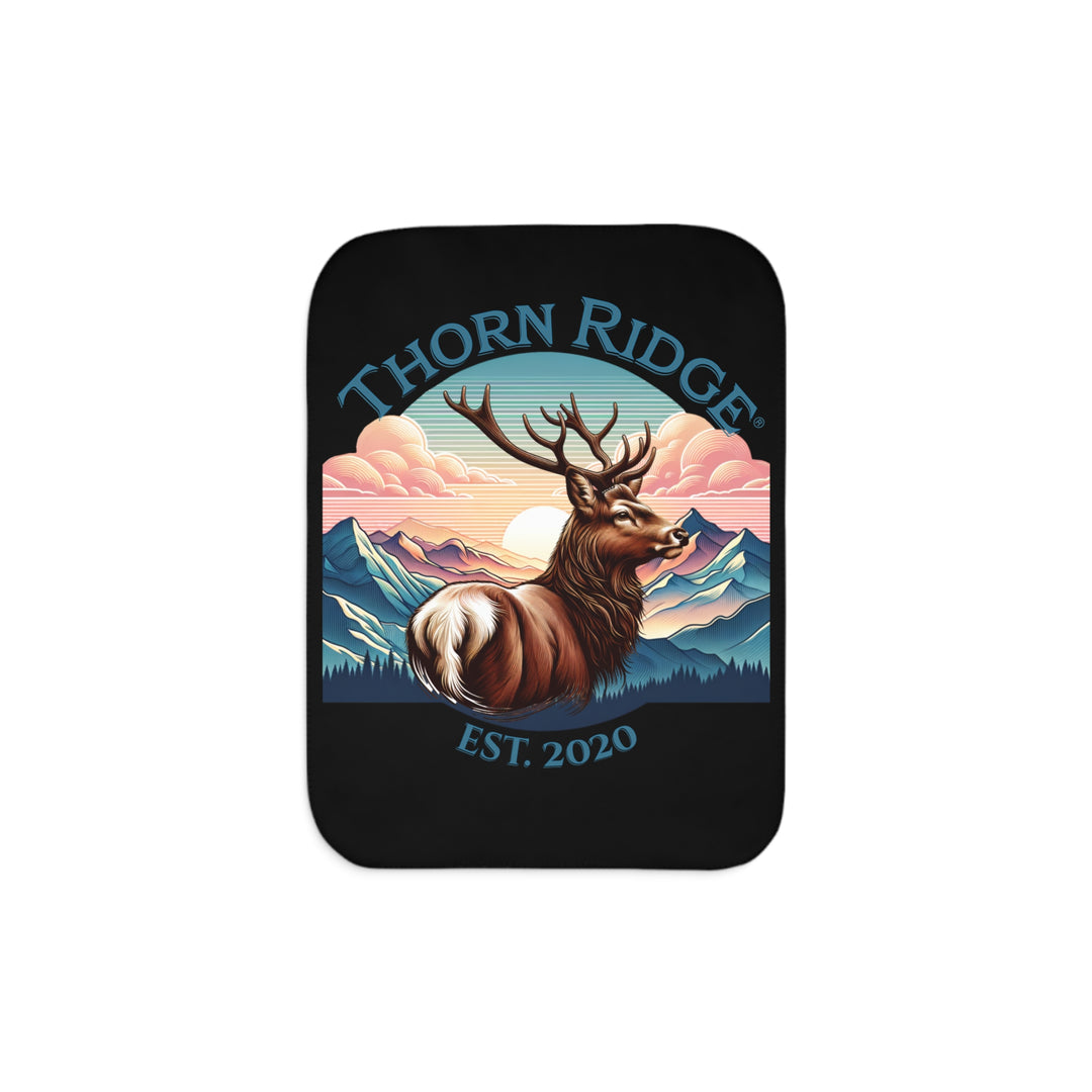 Black sherpa blanket with an illustration of a buck with antlers looking to the right with images of mountains in the background and the text Thorn Ridge® Est. 2020