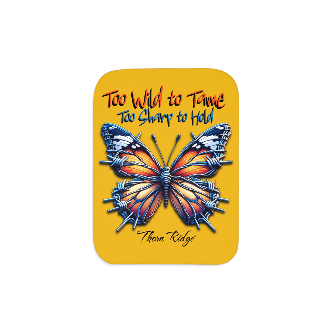 Butterfly design with barbed wire it's wings on a yellow sherpa blanket with text that says Too Wild to Tame Too Sharp to Hold and is the Barbfly legend from Thorn Ridge®