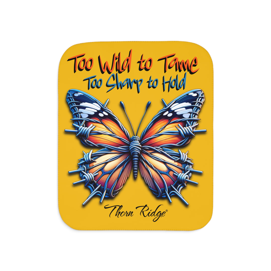 Butterfly design with barbed wire it's wings on a yellow sherpa blanket with text that says Too Wild to Tame Too Sharp to Hold and is the Barbfly legend from Thorn Ridge®