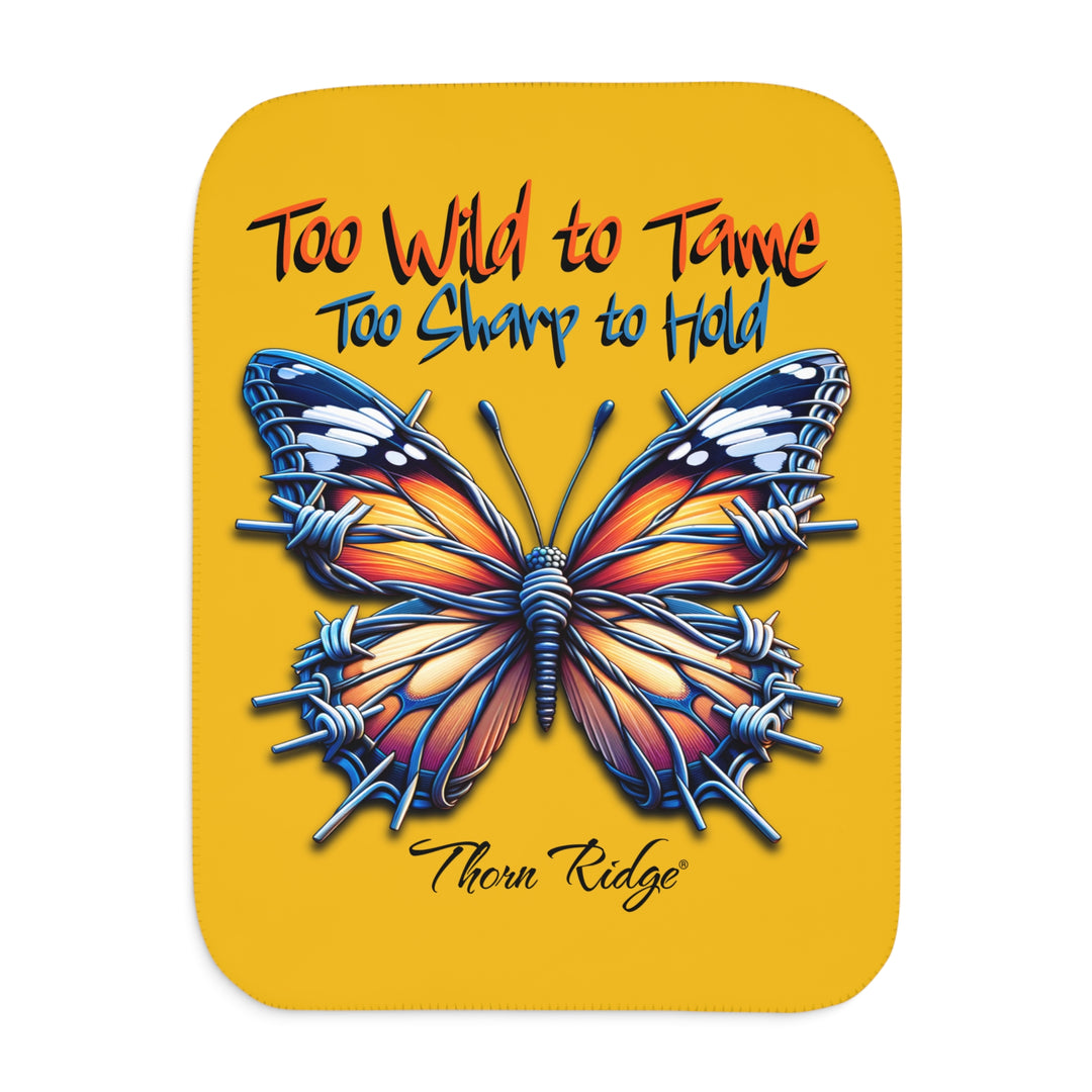 Butterfly design with barbed wire it's wings on a yellow sherpa blanket with text that says Too Wild to Tame Too Sharp to Hold and is the Barbfly legend from Thorn Ridge®
