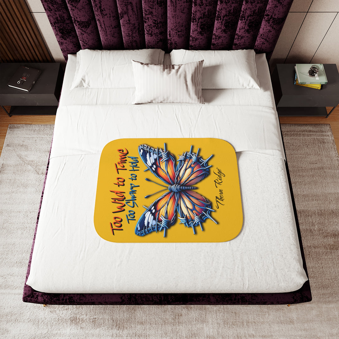 Butterfly design with barbed wire it's wings on a yellow sherpa blanket with text that says Too Wild to Tame Too Sharp to Hold and is the Barbfly legend from Thorn Ridge®