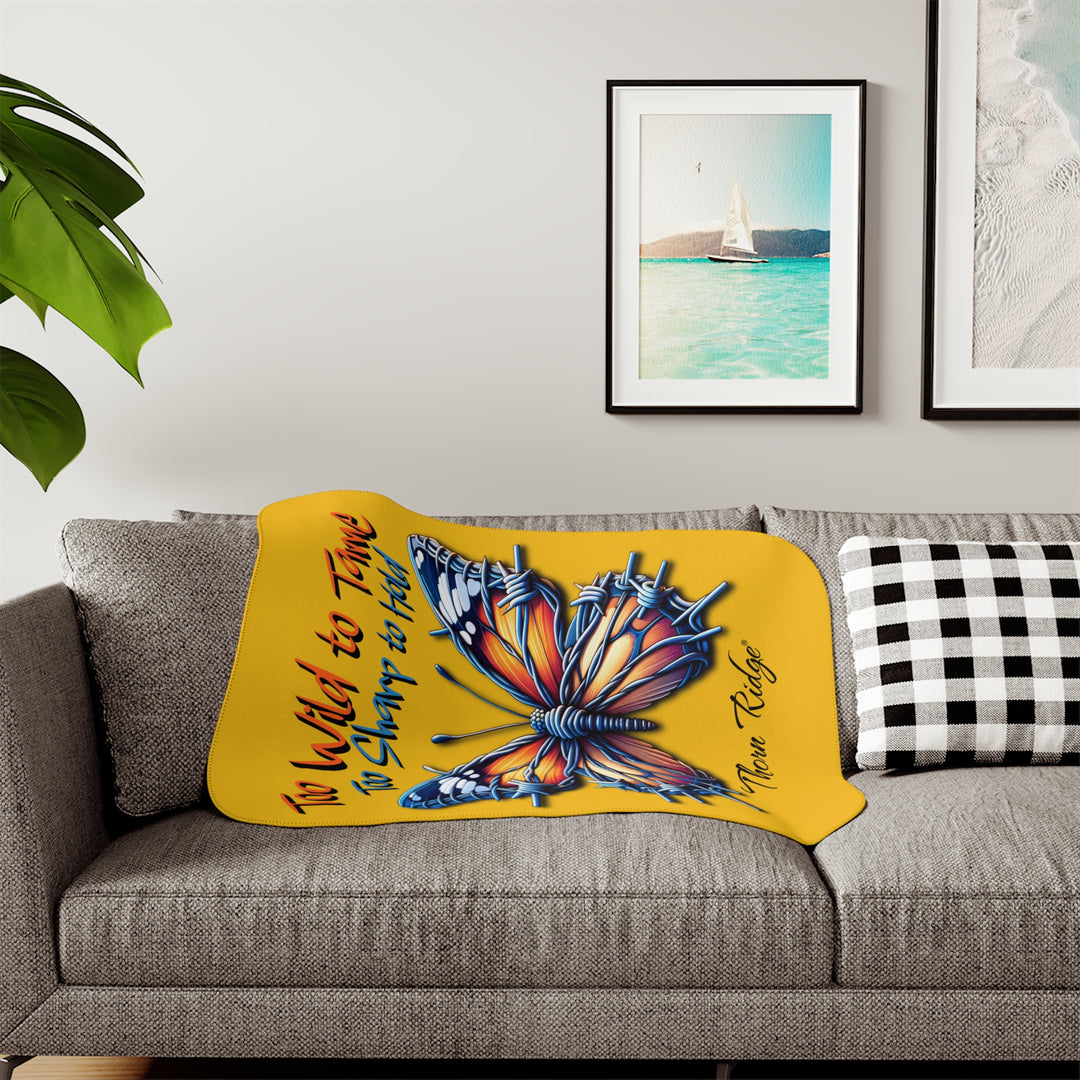 Butterfly design with barbed wire it's wings on a yellow sherpa blanket with text that says Too Wild to Tame Too Sharp to Hold and is the Barbfly legend from Thorn Ridge®