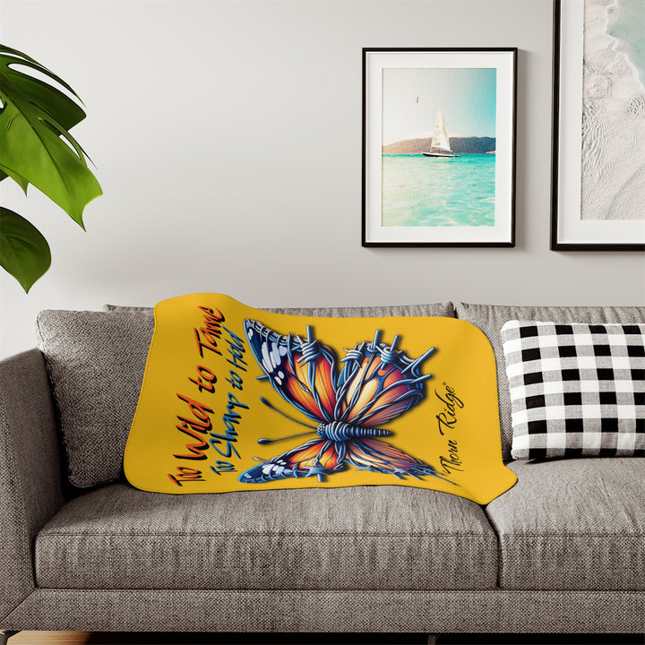 Butterfly design with barbed wire it's wings on a yellow sherpa blanket with text that says Too Wild to Tame Too Sharp to Hold and is the Barbfly legend from Thorn Ridge®