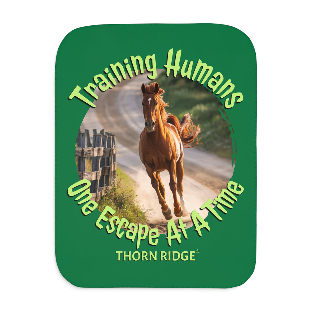 Training Humans One Escape At A Time  green sherpa blanket with the image of a bay horse running down a dirt road alongside a wooden fence. Labeled Thorn Ridge®