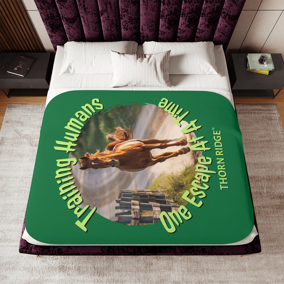 Training Humans One Escape At A Time  green sherpa blanket with the image of a bay horse running down a dirt road alongside a wooden fence. Labeled Thorn Ridge®