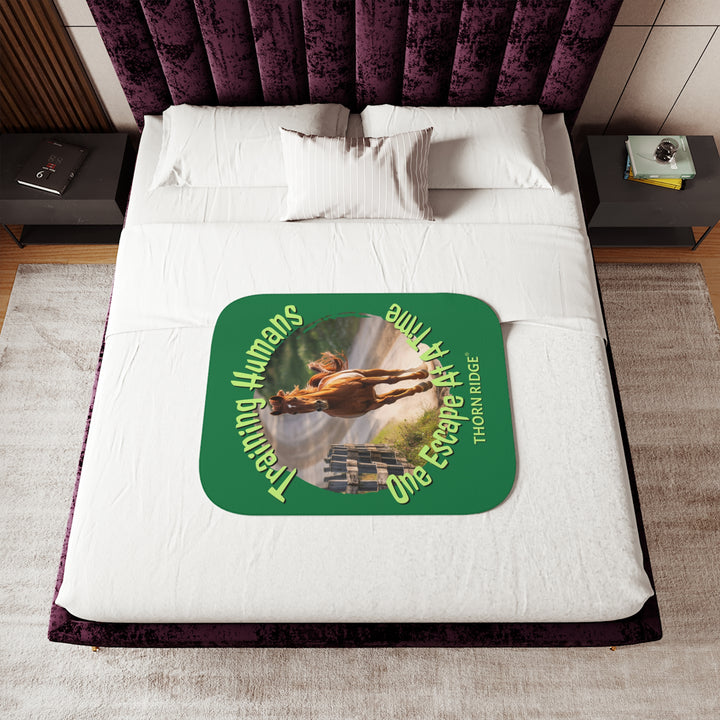 Training Humans One Escape At A Time  green sherpa blanket with the image of a bay horse running down a dirt road alongside a wooden fence. Labeled Thorn Ridge®
