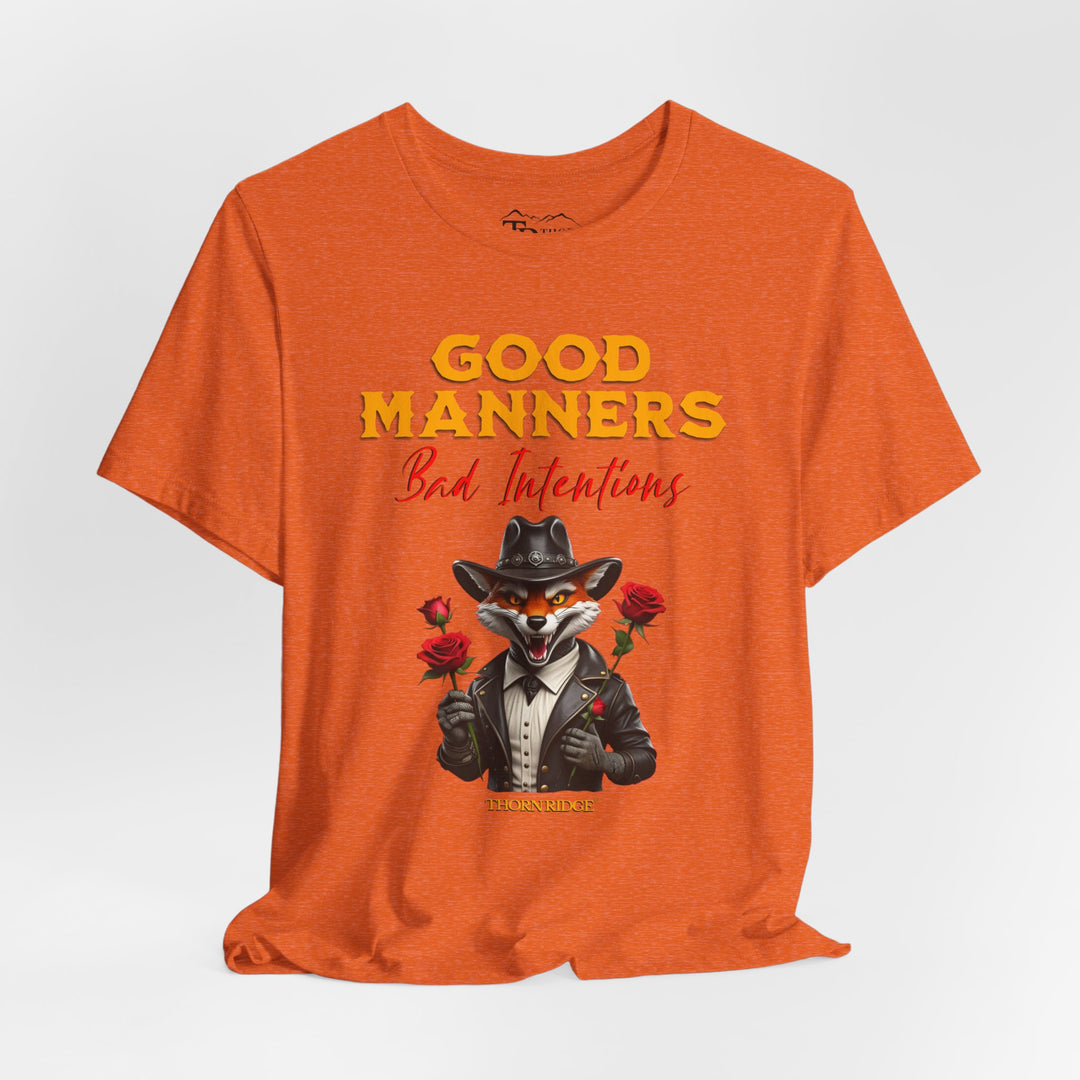 Good manners bad intentions graphic tee with a grinning fox wearing a black cowboy hat and leather jacket with human hands holding roses.  labeled Thorn Ridge®