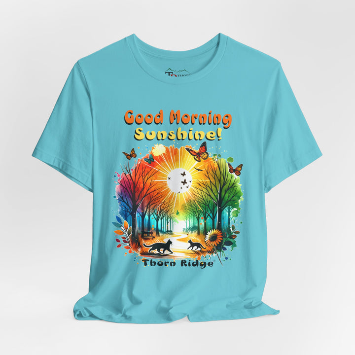 good morning sunshine graphic tee by Thorn Ridge featuring the sun shining through the trees and two cats walking across the path in a park.