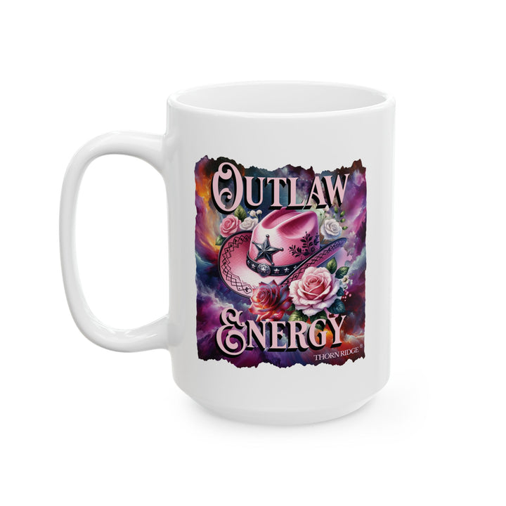 White mug with a colorful design featuring a pink cowboy hat and flowers, labeled 'Outlaw Energy' by Thorn Ridge®