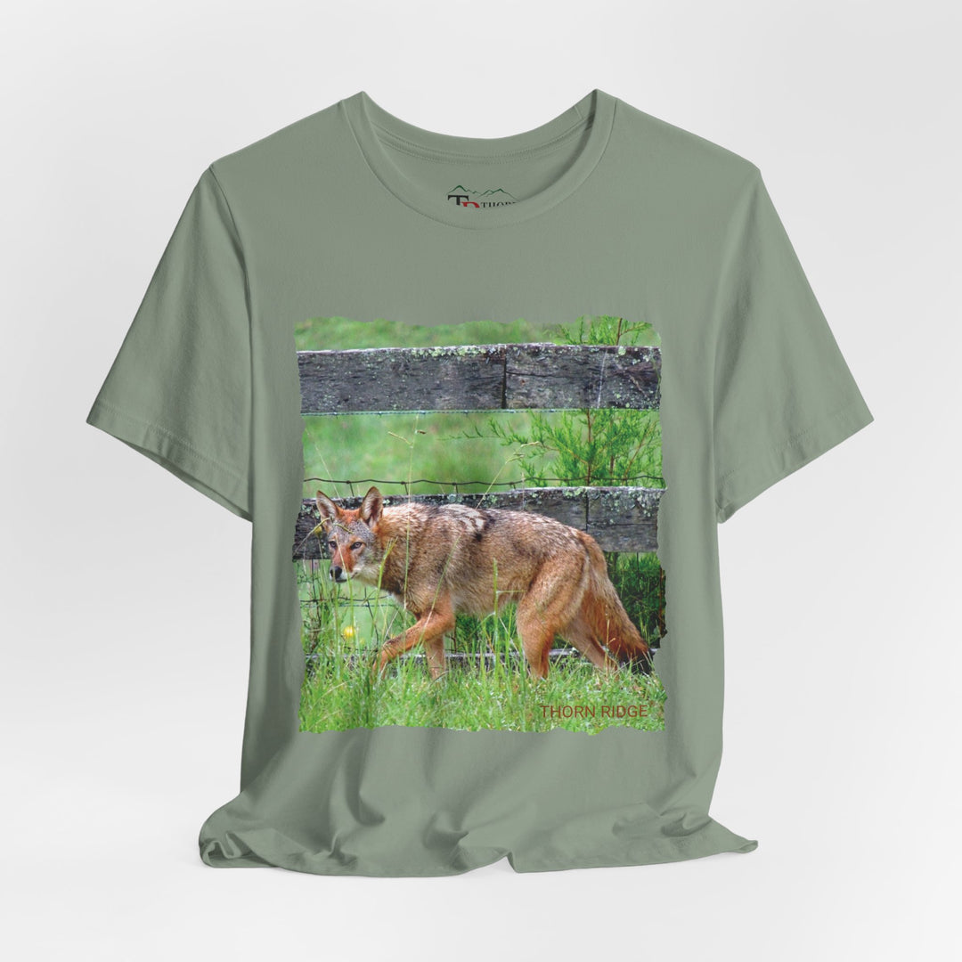 t-shirt with a photo of a red coyote against a weathered board fence and green grass labeled Thorn Ridge®