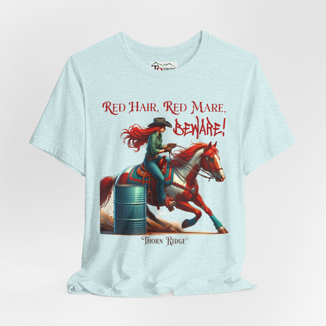 t-shirt with a graphic of a redhead woman on a horse barrel racing and the text 'Red Hair, Red Mare, Beware!' labeled Thorn Ridge®.