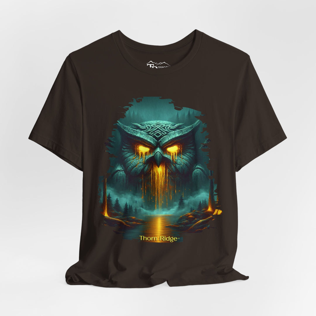 Legend of the Owl King tee by Thorn Ridge with a ancient statue of an owl with glowing lava eyes and mouth in front of a river with fog in the forest. 