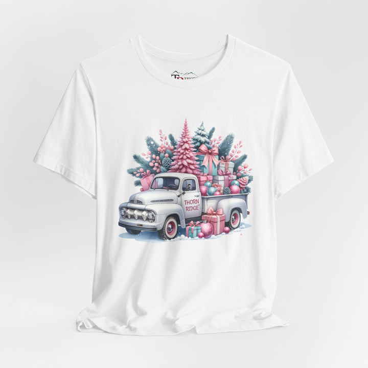 t-shirt with a vintage white truck with the bed filled with pastel colored christmas trees and presents with Thorn ridge on the driver's side door and presents around the door on the ground. 