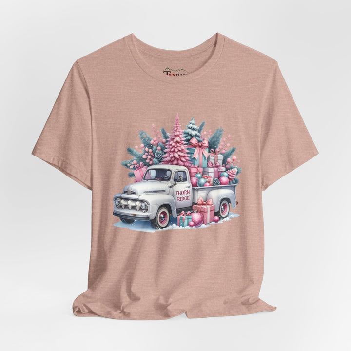 t-shirt with a vintage white truck with the bed filled with pastel colored christmas trees and presents with Thorn ridge on the driver's side door and presents around the door on the ground. 
