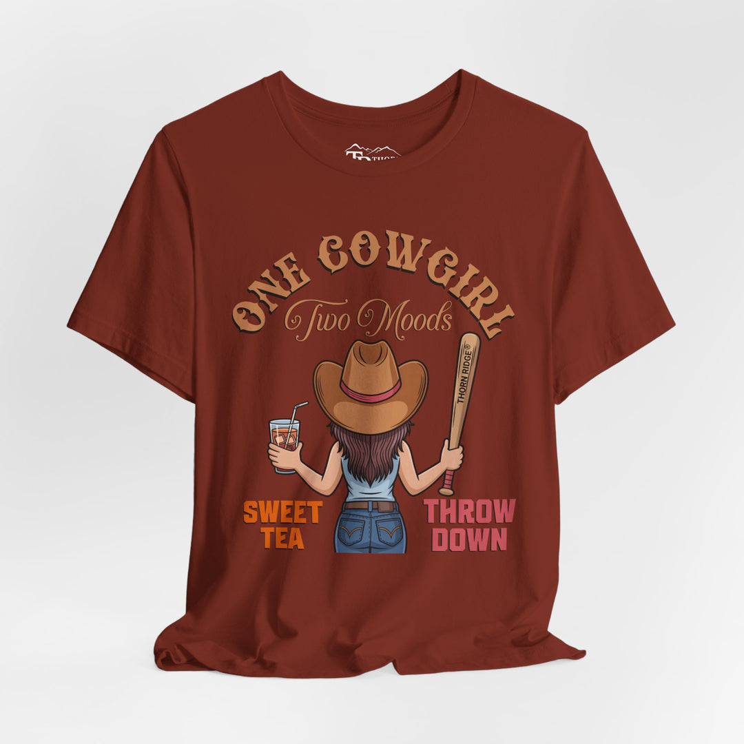 t-shirt with a graphic of a cowgirl holding a drink and a bat, with text 'One Cowgirl Two Moods Sweet Tea Throw Down' labeled Thorn Ridge®