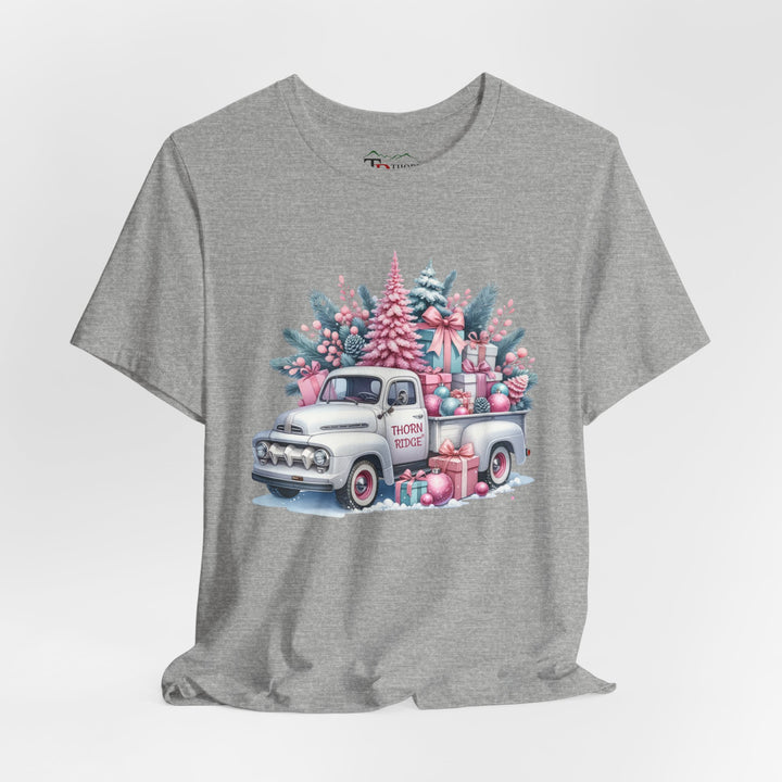 t-shirt with a vintage white truck with the bed filled with pastel colored christmas trees and presents with Thorn ridge on the driver's side door and presents around the door on the ground. 