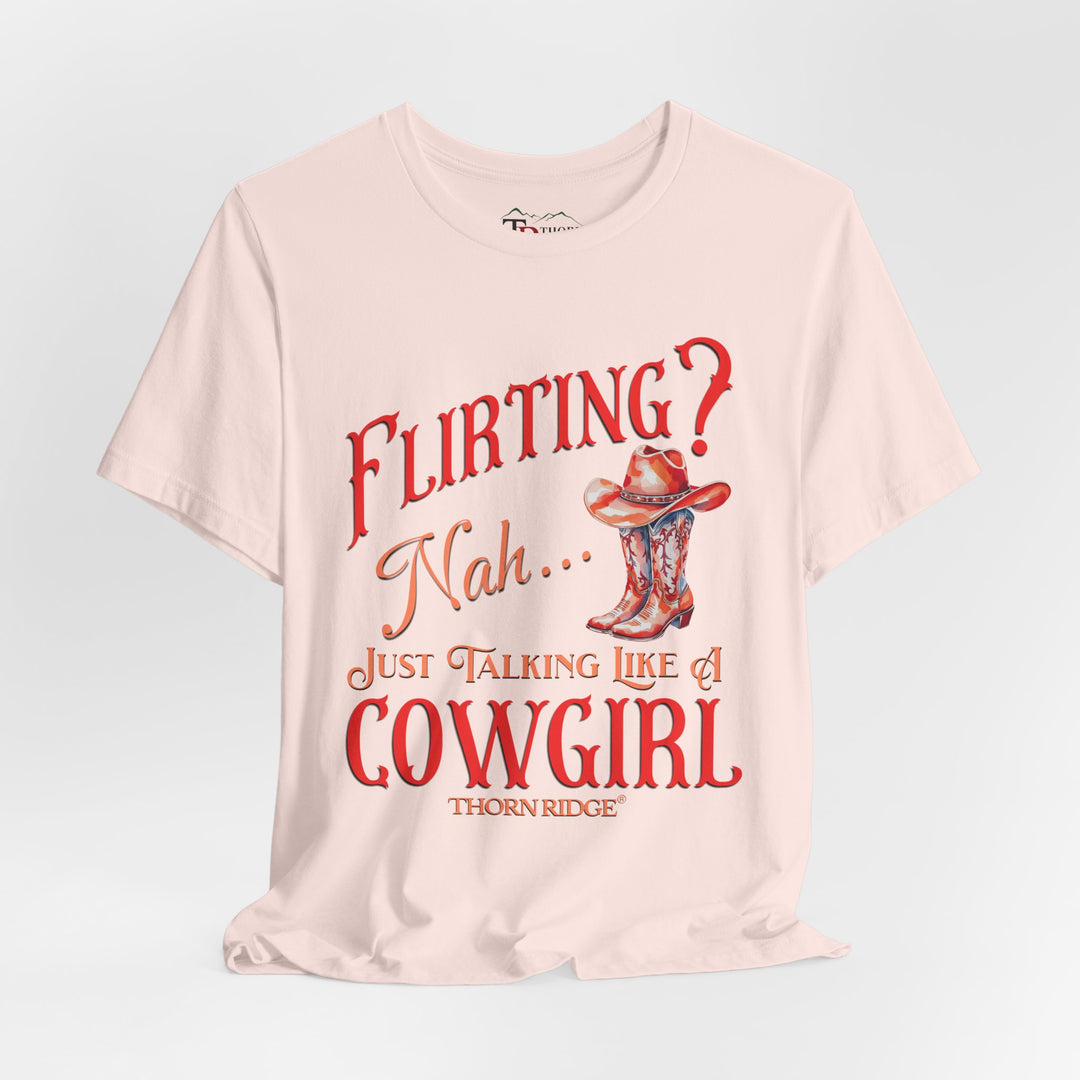 "Flirting? Nah... just talking like a cowgirl" graphic tee with women's cowgirl boots with a cowgirl hat sitting on top. Labeled Thorn Ridge®