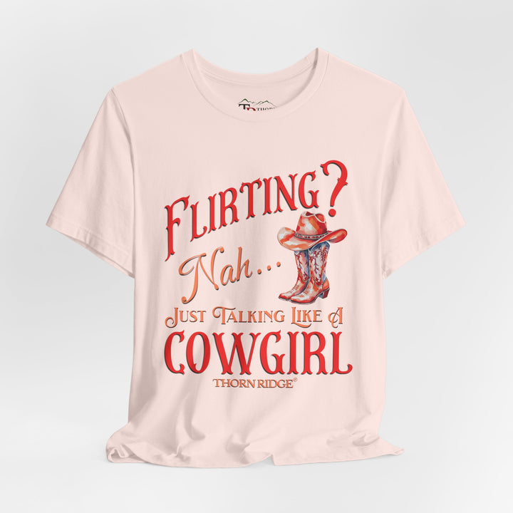"Flirting? Nah... just talking like a cowgirl" graphic tee with women's cowgirl boots with a cowgirl hat sitting on top. Labeled Thorn Ridge®