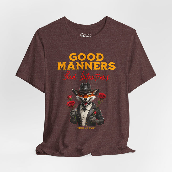 Good manners bad intentions graphic tee with a grinning fox wearing a black cowboy hat and leather jacket with human hands holding roses.  labeled Thorn Ridge®