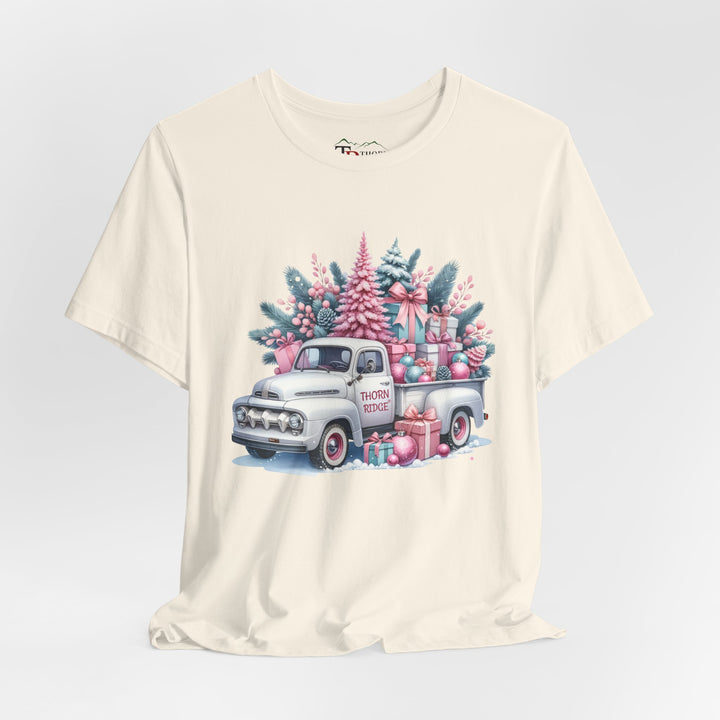 t-shirt with a vintage white truck with the bed filled with pastel colored christmas trees and presents with Thorn ridge on the driver's side door and presents around the door on the ground. 