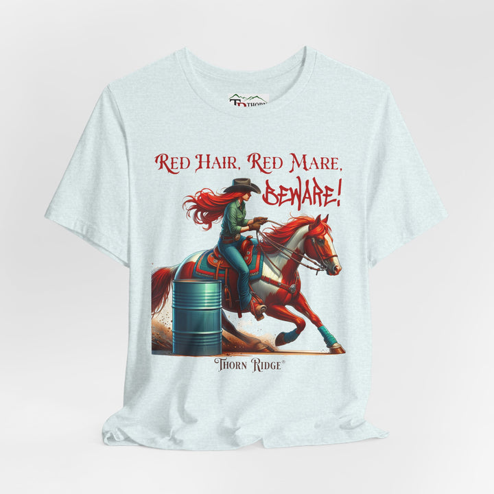 t-shirt with a graphic of a redhead woman on a horse barrel racing and the text 'Red Hair, Red Mare, Beware!' labeled Thorn Ridge®.