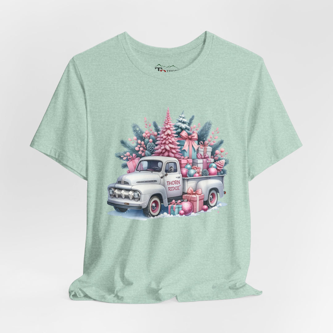 t-shirt with a vintage white truck with the bed filled with pastel colored christmas trees and presents with Thorn ridge on the driver's side door and presents around the door on the ground. 