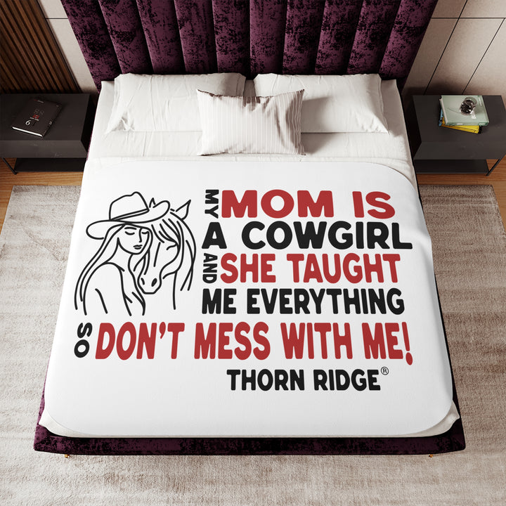 Mom Is A Cowgirl and she taught me everything so don't mess with me slogan graphic with a outline drawing of a woman with a cowboy hat hugging a horse by Thorn Ridge®