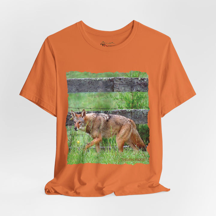 t-shirt with a photo of a red coyote against a weathered board fence and green grass labeled Thorn Ridge®