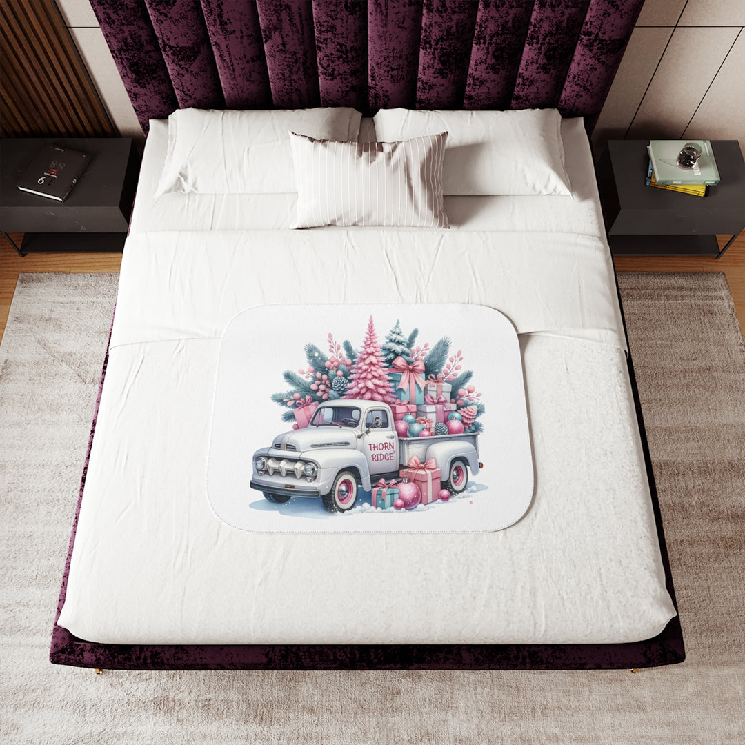 Vintage truck decorated with Christmas trees and presents on a white background with Thorn Ridge® branding on the door. Lying across a bed