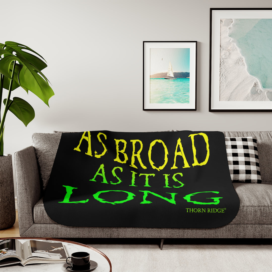Black sherpa blanket with yellow and green text 'AS BROAD AS IT IS LONG' and 'THORN RIDGE' branding.