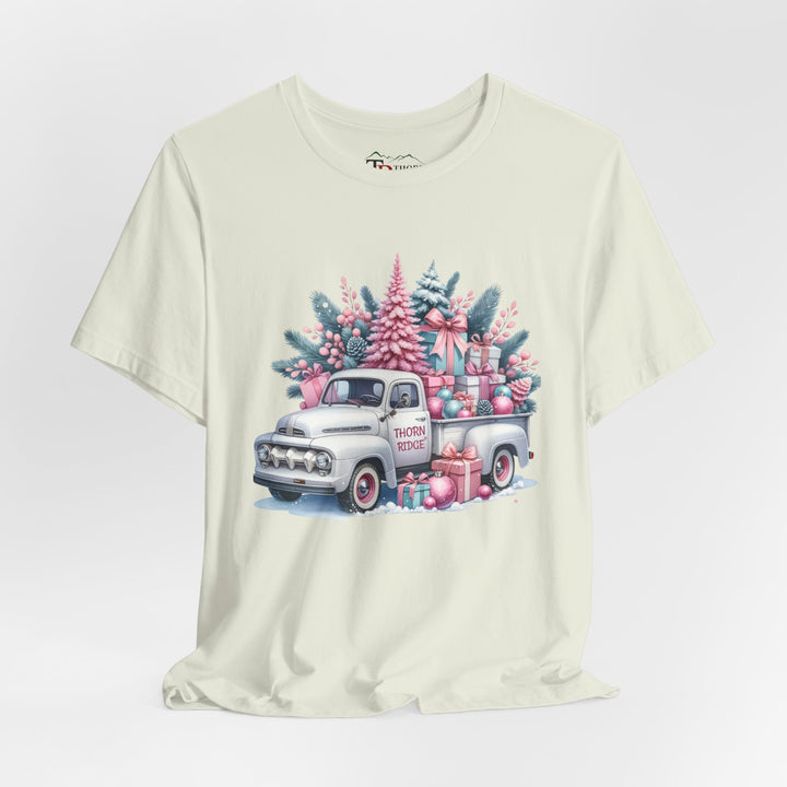 t-shirt with a vintage white truck with the bed filled with pastel colored christmas trees and presents with Thorn ridge on the driver's side door and presents around the door on the ground. 