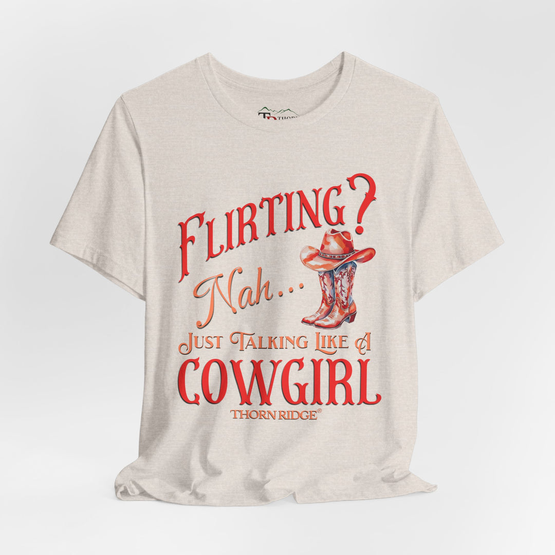 "Flirting? Nah... just talking like a cowgirl" graphic tee with women's cowgirl boots with a cowgirl hat sitting on top. Labeled Thorn Ridge®